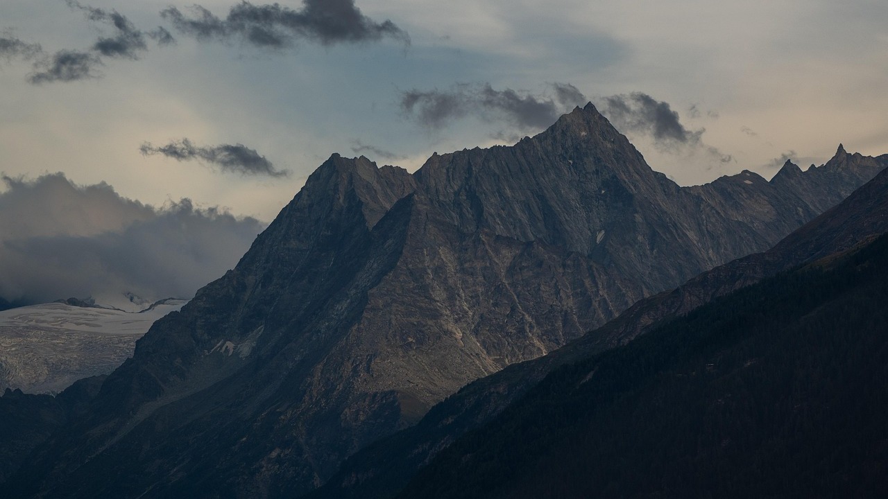 Rugged Swiss alpine peaks in heavy clouds with a glacier below